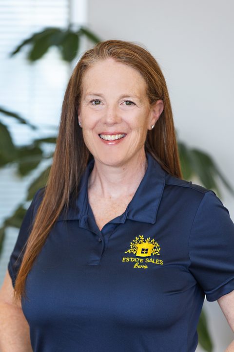 A member of the Estate Sales Barrie team in a branded navy polo shirt with the company's house-and-tree mark embroidered in gold.